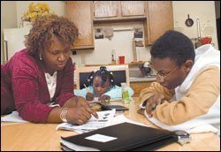 Santia Bennett helps her son, Julius, and her 5-year-old daughter, Jewels, with their homework at the familiy's kitchen table. The single mother, who works two jobs and plans to go to law school, says that Julius' success depends greatly on his continuing at Amistad, which plans to open a high school in New Haven in the fall.