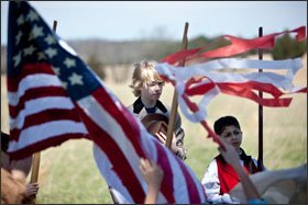 Thomas Strickland, center, with Anthony Jacques standing guard, announces the fall of Richmond, Va., as 6th graders from Stonewall Jackson Middle School, in Manassas, Va., reenact and film civilian life during the Civil War at the Manassas National Battlefield Park.