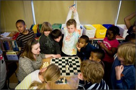 Kelsey Williams, seated at left, leads students through a chess match at Faubion. Such activities have helped generate community engagement in the pre-K-8 school, according to educators, and now Faubion has to hold its parent-teacher-association meetings in the gymnasium to accommodate all the parents who want to attend.