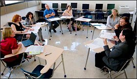 Teachers give their opinions during a class led by data coach Brenda Dorrell, of Wireless Generation, with laptop, at Delcastle High. Ms. Dorrell meets once a week with English teachers at the school as well as those at Howard High School.