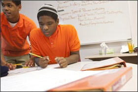 Demondre, right, and Marcus work on an assignment during social studies class at the Maya Angelou school.