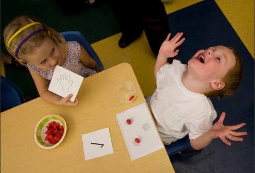 Kira Alley and Nicholas Goodwin play a counting game as part of the Tools of the Mind program at Norma Anderson Preschool in Wheat Ridge, Colo.