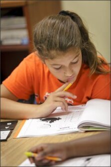 Eleven-year-old Kaity Matthews, a rising 6th grader at Du Bose Middle School in Summerville, S.C., contemplates a problem on her worksheet at the "Fraction Action" summer camp.