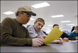 Randy Lord and his son, Kalvin, review a class schedule during a planning session.