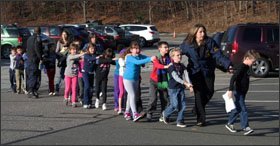 On the day of the shootings, police lead a line of Sandy Hook students to safety.