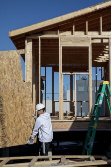 Sophomore Rodney Arnold, 16, carries a piece of plywood as students continue construction on a tiny house on Friday, March 22, 2019 at Battle High School in Columbia, Mo. Students in a combined construction and geometry class are building a tiny house for a low-income family in the community.