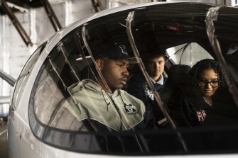 Sophomore Byron Barksdale, left, and classmates from Magruder High School’s aviation program examine the inside of a charter plane at the Montgomery County Airpark in Gaithersburg, Md., on April 6, 2022.