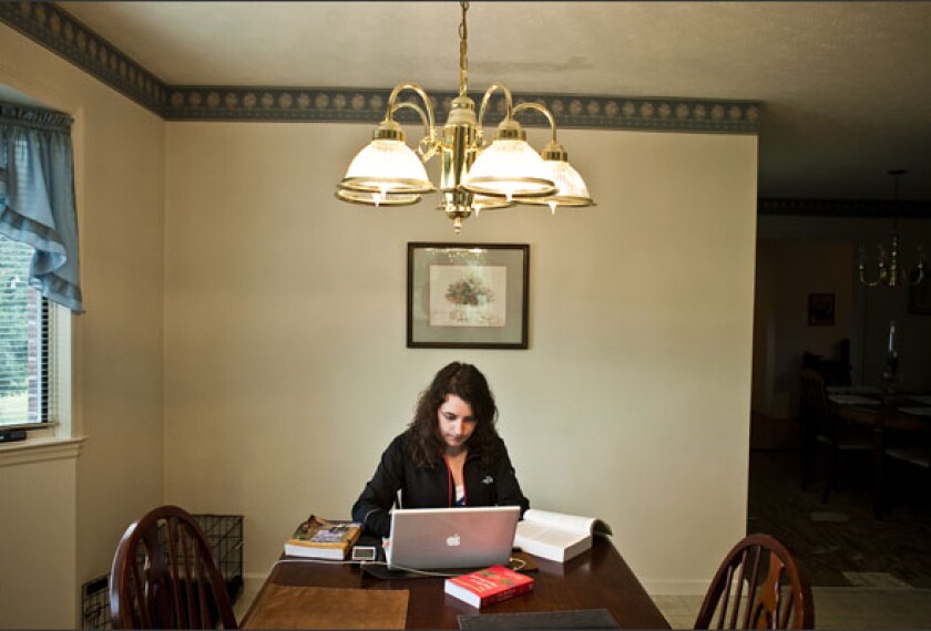 Kelsey Stephenson works on an online course from her kitchen after school. Her district, the Putnam County, Tenn., schools, requires that students take at least one online course to graduate.