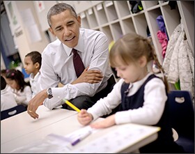 President Barack Obama sits with Emily Hare as she completes her spelling lessons during his visit to a preschool classroom at Powell Elementary School in the Petworth neighborhood of Washington.