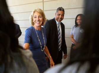 Accompanied by principal Anthony Cherry, DeVos is greeted by students at the 21st Century Charter School in Gary, Ind.