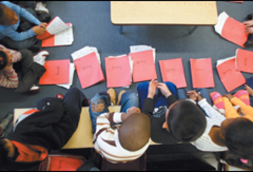 First graders at PS 33 in the Chelsea neighborhood of Manhattan sit in a semicircle during a meeting with teacher Danielle Capek. The city education department's directions on teaching literacy, in particular, have raised some educators' hackles.