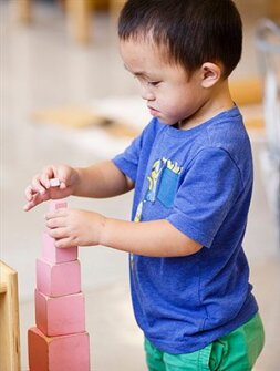 Camden, a preschooler, stacks blocks at the MacDowell Montessori School in Milwaukee. Amazon CEO Jeff Bezos experienced a similar Montessori education as a child.