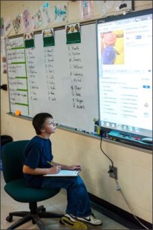 Whittemore Park 6th grader Jason Bellnier reads from a projected Web screen to complete a “performance task” for a math class.