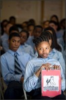 Shakora Ragland, a 7th grader, attends a weekly community meeting at the school. She was selected to lead her class and hold up the clipboard when her grade was recognized.