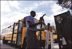 June Brown, a maintenance worker at the Laidlaw Transit school bus yard in Hamilton, N.J. replaces the pump nozzle after filling the tank of a school bus with diesel fuel on Aug. 23.