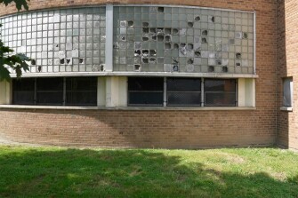 Broken windows are seen outside Cody High School in Detroit on Aug. 20, 2021. The district is using some of its money provided by the government to hire tutors, expand mental health services and cut class sizes. But at least half of its $1.3 billion windfall is being set aside to make long-neglected repairs.