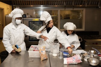 Kermir Highsmith, left, Dynasty McClurk, center, and Nevaeh Williams, work in their culinary arts class at Westinghouse High School in Pittsburgh, Pa., on Dec. 13, 2022.