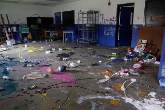 Closed in 2015, the Hughes High School still stands, littered with remnants of its past, and marked by graffiti from vandals.