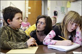 Melissa Romano works with 2nd graders Konnar Smith and December Frost on their algebra assignment at Broadwater Elementary in Helena, Mont. Teachers are introducing such math concepts in the early grades.
