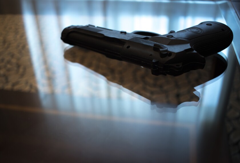 Image of a gun sitting on a glass table.