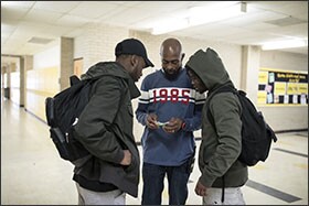 Montrell Williams, a "community ambassador" at Como Park High School, asks to see students' hall passes late last year. Williams helps supports security in the school by monitoring hallways and keeping up with local happenings outside of the school that could impact students while they're on campus.