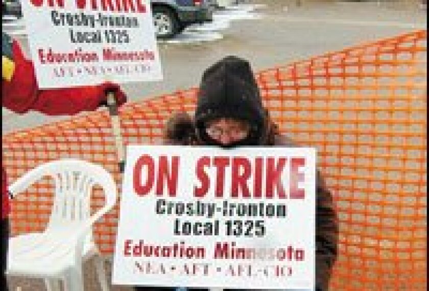 A picketer at Crosby Ironton High rests her chin on a sign. The strike is the first in the state in two years.
