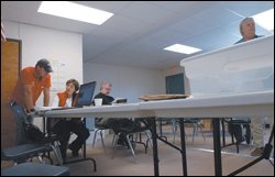Kim Stasny, seated, the superintendent of the Bay St. Louis-Waveland, Miss., district, speaks with a U.S. Army Corps of Engineers official at a January meeting that included officials of FEMA.