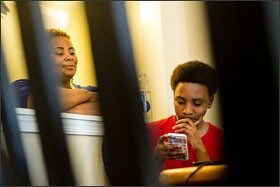Cameron Davis, 12, works on a homework assignment on his iPhone while his mother, LaToya C. Staten, looks on at their Pasadena, Md., home.