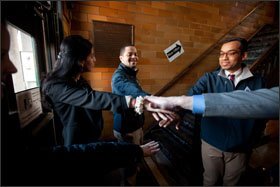 Komal Bhasin, left, the principal of UP Academy Leonard Middle School in Lawrence, Mass., rallies with teachers before students arrive.