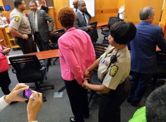 A Fulton County Sheriff’s Deputy handcuffs former Atlanta’s Public Schools school research team director Sharon Davis Williams, center, after a jury found her guilty in the school district’s test-cheating trial.