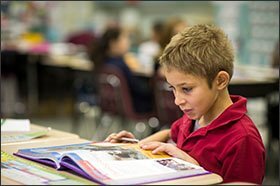 Third grader Matthew Lindemuth searches through his textbook at McKinley Elementary, a traditional brick-and-mortar school in Erie, Pa. Erie’s regular public schools face competition from charters, which educate more than 10 percent of the district’s 12,000 students.