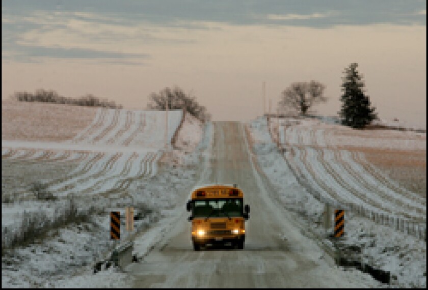 A school bus passes snow-dusted fields on a late-afternoon route in Anamosa, Iowa. Local school officials have mixed feelings about the state's hands-off approach to standards.