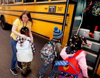 Sara Black, a teacher at Glen Lea Elementary School in Henrico County near Richmond, Va., hugs a student goodbye on Friday, March 13, 2020. Virginia Gov. Ralph Northam ordered all schools in Virginia to close for at least two weeks as the coronavirus spreads, a move that follows similar orders in several other states.