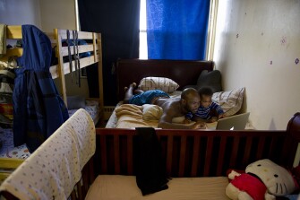 Troy Bakker, Mills’ boyfriend, spends time with their son Blake Bakker, 11 months, as he works on his laptop.