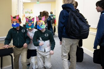 Students from Kesling St. Denis’ art class run through the halls with their completed bunny masks as older students pass between classes on March 30, 2023.