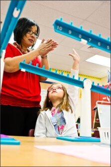 Nena Hupp helps Chase Toler in her class at Worthington Elementary School. Students in the Howard County, Md., district are being taught math concepts at an earlier age.
