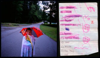 Wrapped in a blanket and protected from sprinkles of rain by her Cars umbrella, Susanna Spalding, 6, hums a song to herself as she walks with her counselor back to the group lodge at Mountain Adventure Camp, 7/17/08.