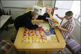 Mike Ruiz, left, selects a candy bar from Stephen Fraser, who manages the student lounge at lunchtime at the Denver Street School in Lakewood, Colo.