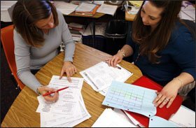 Coach Melissa Jennings points to test scores as she and Kendra Pollard try to figure out what version of math the teacher can offer a more advanced student.