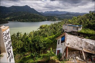 The view overlooking Lake Coanillas in Utuado. The graffiti on the left says, “We are in the next house up the hill.”
