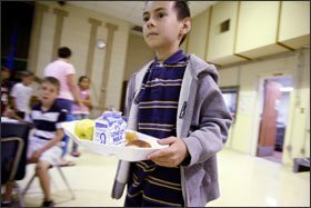 Eric Ingle makes his way to a table during lunch hour at Western Winds Elementary School. The district uses its data system to manage its food services, including making sure that all eligible children are enrolled in the federal free and reduced-price meal programs.
