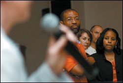 New Orleans residents listen as Robin Jarvis, left, the acting superintendent of the state-run Recovery School District, explains for next school year at May 24 meeting at a church in the city.