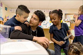 El maestro adjunto, Richard Nolasco, escucha a Joshua Flores y Ke’mari Barnes durante sus clases en el pre-kinder en la Academia de Dos Idiomas de Tulsa. La población del segundo distrito escolar más grande de Oklahoma ha cambiado drásticamente en los últimos años, con casi 1 de cada 3 estudiantes provenientes de hogares donde el español es el idioma principal.