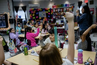 Second grade students raise their hands in Dalia Gerardo's classroom at West Elementary, in Russellville, Ala., on Dec. 9, 2022.