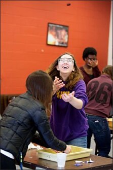 Sarah Leahy, a student at the Illinois Mathematics and Science Academy, is poised to catch the lid from an exploding film can after mixing water and Alka-Seltzer inside. The students are participating in a training program that prepares them to lead inquiry-based projects.