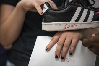 A student at Polo Park Middle school displays a shoe signed by Boursiquot during the tutor's visit to the Wellington, Fla., school.