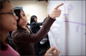 Maria Reyes, an 8th grader at R.M. Marrs Magnet Center in Omaha, Neb., helps a fellow student. Scholars and activists suggest more money for magnets.