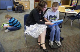 Greta Smith reads to her special education class at Buhler Grade School in Buhler, Kan. Ms. Smith works with a range of technologies available to her students. The school is field-testing assessments aligned to the Common Core State Standards and designed for students with severe cognitive disabilities.