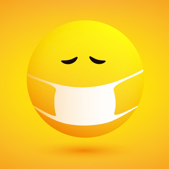 Image shows a bright background of yellows and oranges with a sad and concerned emoji wearing a medical mask over its mouth.