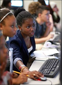 Moneyeke Martin, a 14-year-old student at Bair Middle School in Sunrise, Fla., works on an assignment during her Virtual Learning Lab with classmate Jasmine Royer, also 14. Students at the school collaborate with classmates to complete online assignments.